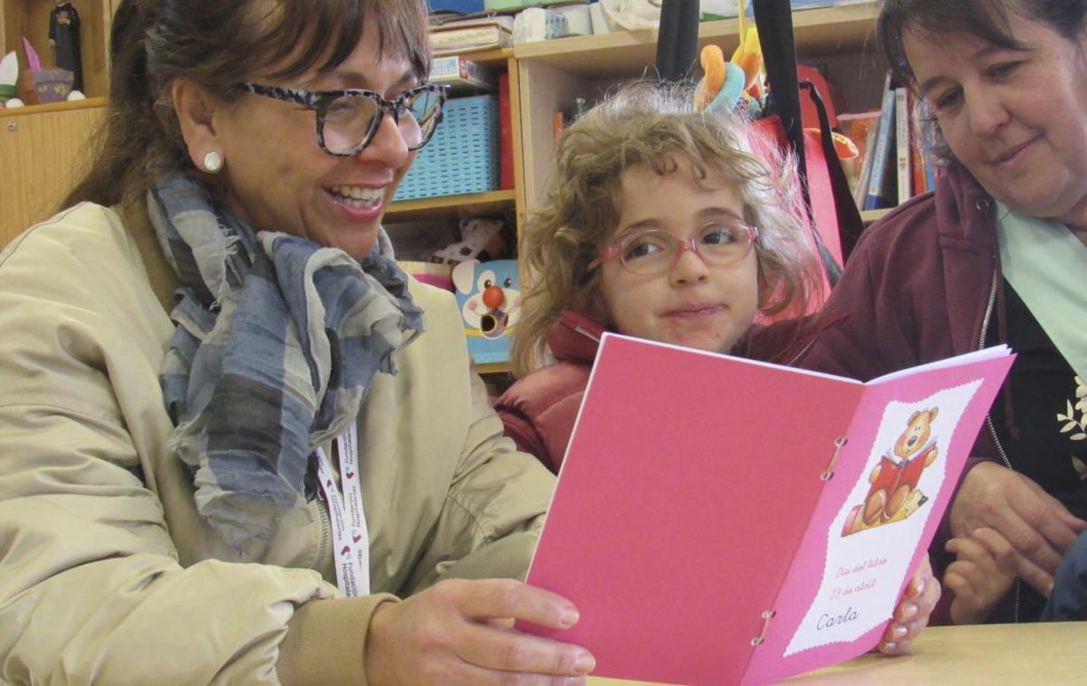 Dos de nuestras docentes comparten un momento de lectura con una alumna, fomentando el aprendizaje.