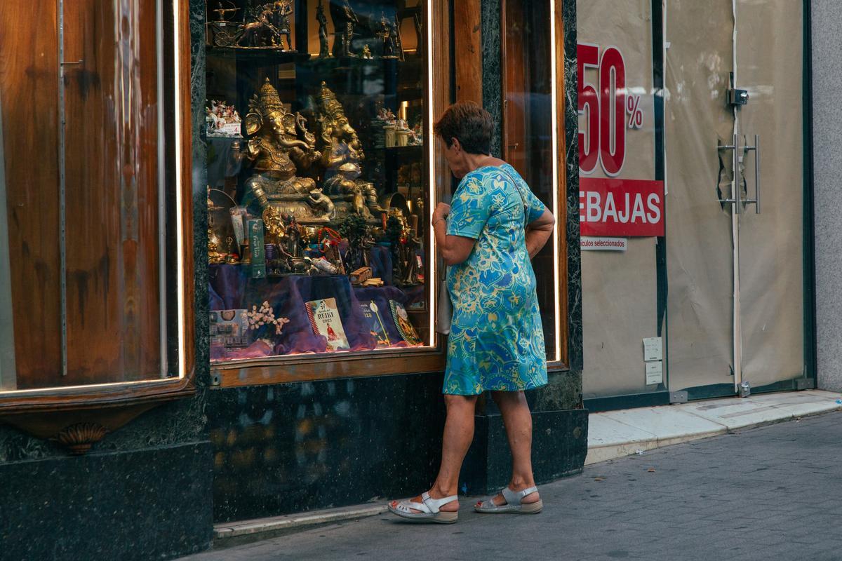 Una mujer observa un escaparate de la calle de Carretas, en Madrid. 