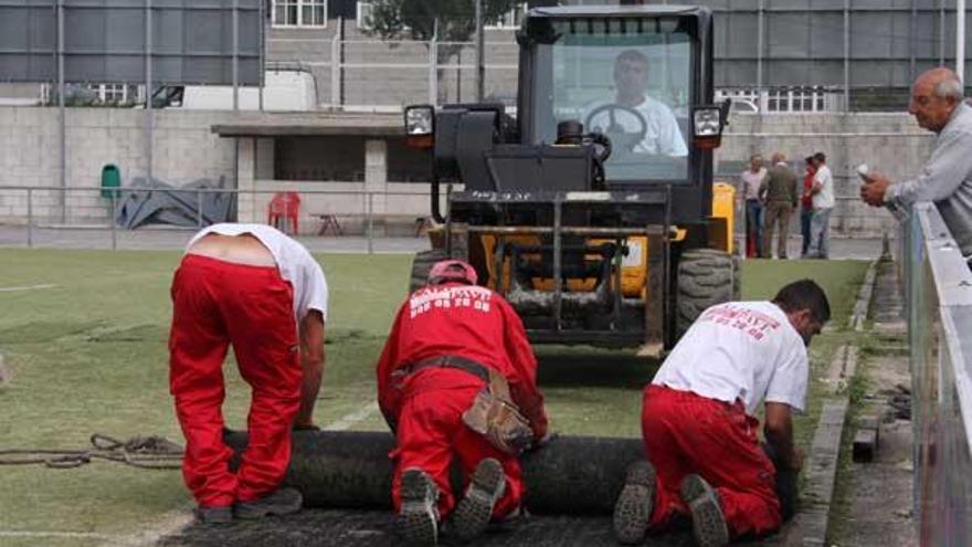 Unos operarios comienzan a levantar el césped artifical del Baltasar Pujales.