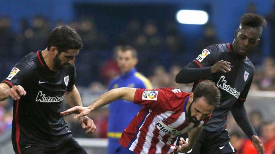 Juanfran Torres, del Atlético, disputa el balón con Iñaki Williams, del Athletic. // Kiko Huesca