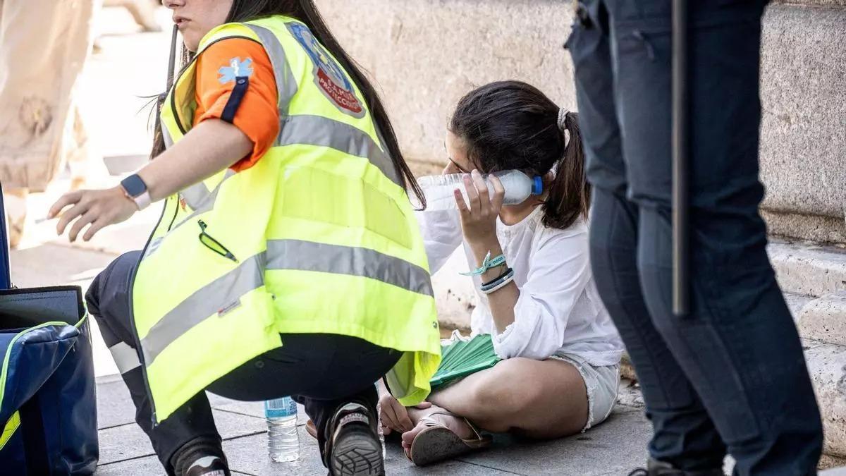 Una persona es atendida por un golpe de calor en plena calle.