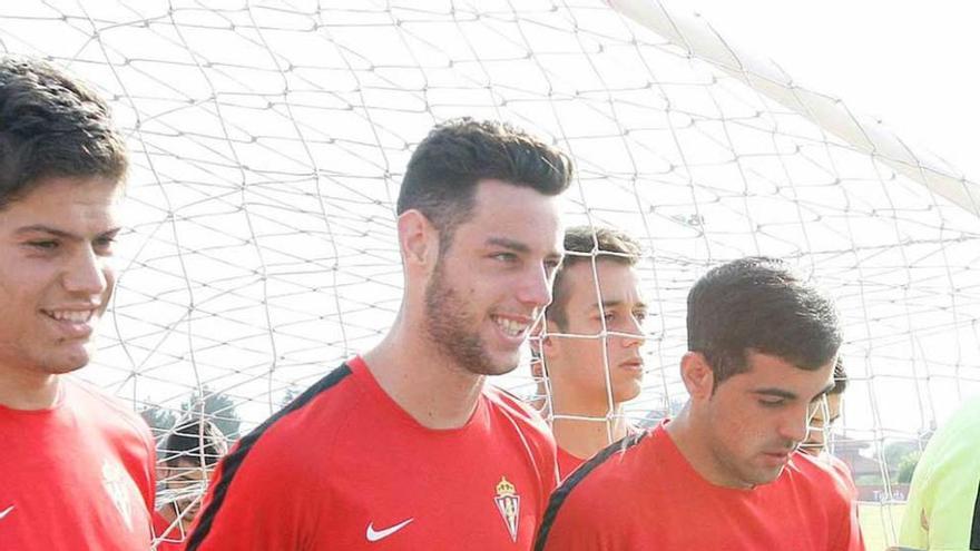 Burgui, en el centro, entre Jorge Meré y Carlos Castro, carga con una portería en el entrenamiento de ayer.