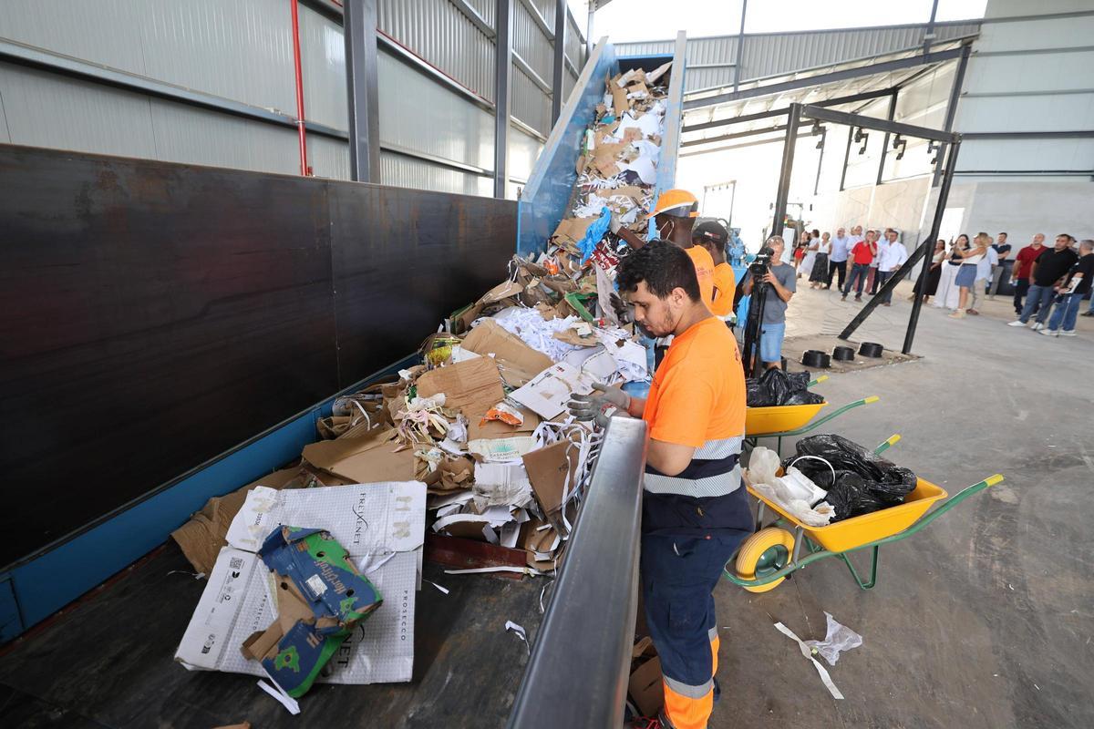 Unos operarios desechan el material inadecuada en la cinta de triaje.