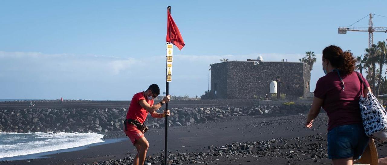 Un socorrista coloca la bandera roja en la playa del Castillo, en Puerto de la Cruz