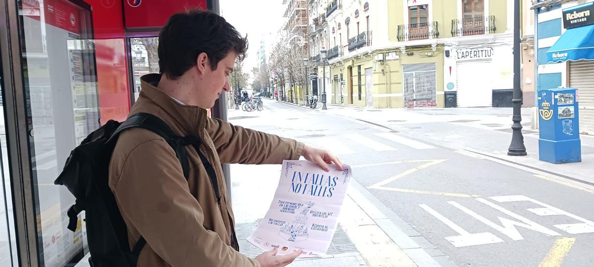 Un vecino de Russafa mira el cartel de la campaña contra el incivismo.