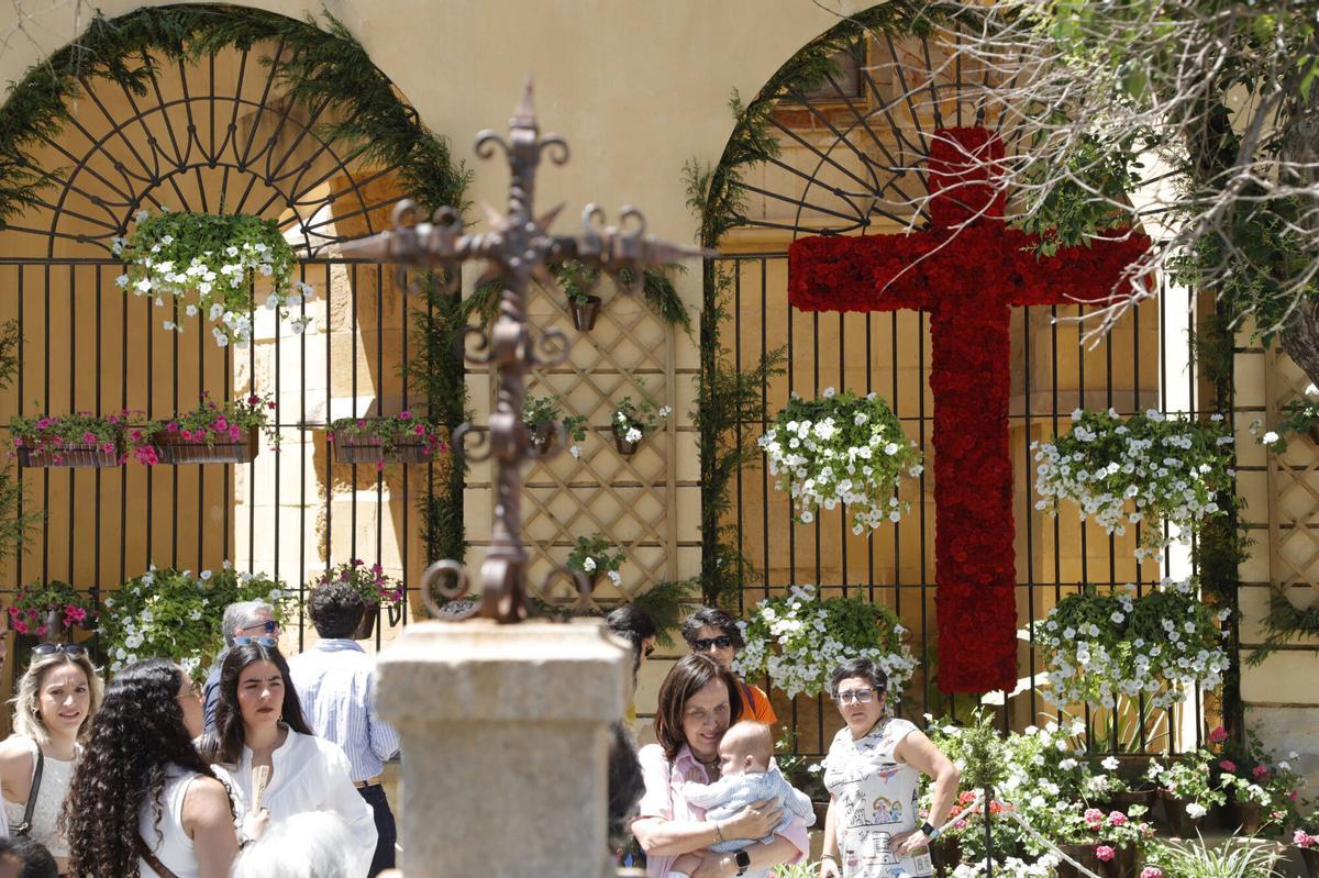 Varias personas junto a la Cruz de Mayo de la hermandad de la Misericordia, en la plaza de San Pedro.