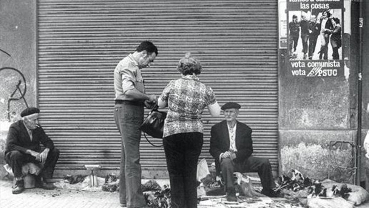 1977. Un hombre vende revistas y otros objetos de segunda mano en una acera de Barcelona en vísperas de las elecciones.