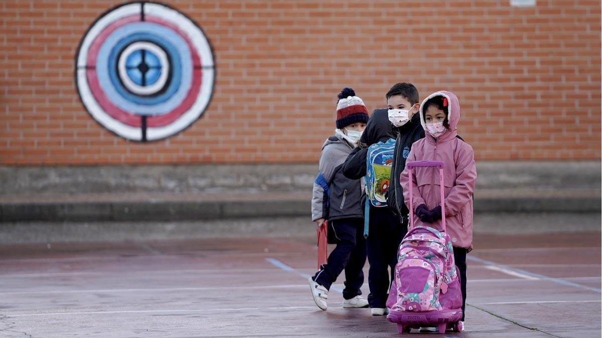 Niños en el patio de una escuela, a su entrada al centro