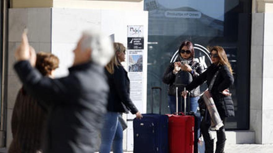 Turistas caminan hacia su alojamiento por la céntrica calle Larios de la capital malagueña.