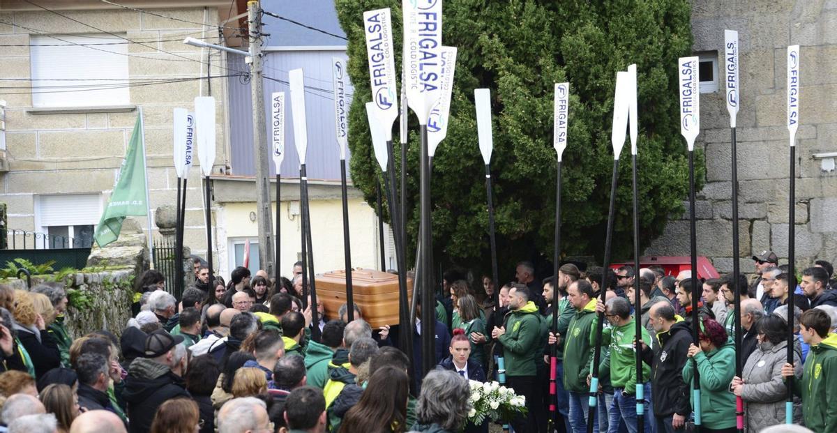 El féretro de José Luis Macey fue recibido en la iglesia de Meira por sus excompañeros con los remos en alto.