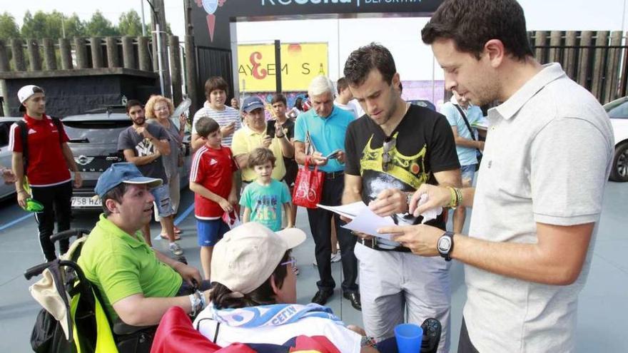 La afición aprovecha la jornada de puertas abiertas en A Madroa - Numerosos seguidores aprovecharon el entrenamiento a puerta abierta que ayer celebró la plantilla del Celta para acercarse a las instalaciones de A Madroa, donde al finalizar la sesión de trabajo solicitaron autógrafos y compartir fotografías con los jugadores y los técnicos del equipo vigués. En la imagen superior, Giuseppe Rossi atiende a varios aficionados en la zona del aparcamiento de la ciudad deportiva. El italiano afronta su segunda semana en Vigo.