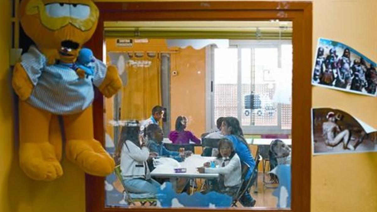 Unos niños meriendan en una sala de Itaca, en el barrio de la Torrassa de L'Hospitalet, poco después de salir de la escuela.