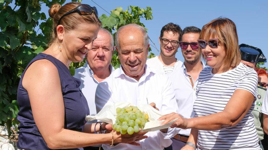 La consellera Elena Cebrián, el presidente de la DOP, José Bernabeu, y la cocinera San Román con el primer racimo de uva de mesa