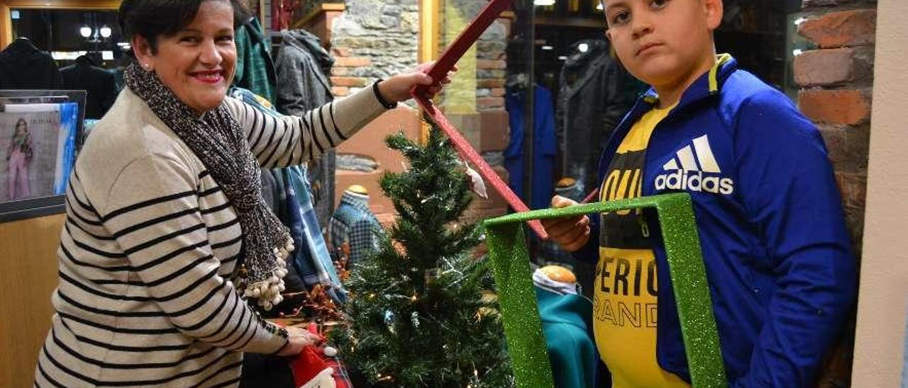 Isabel Menéndez y Sergio Pérez, decorando su escaparate, ayer, en Luarca.