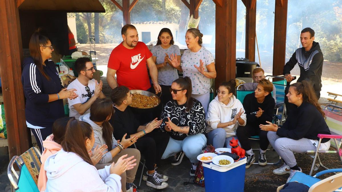 Un grupo de amigos muestra el perol de migas que tenían preparado para la comida