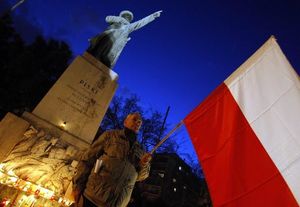 A man holds a Polish flag in Budapest, during a candlelight commemoration for the victims of an air crac in Russia