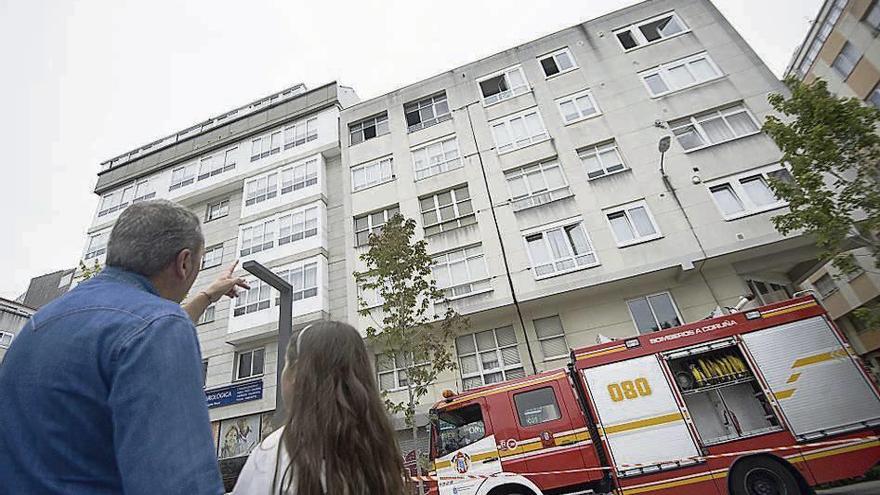 Un veciño señala la planta del edificio donde fue el incendio. // FdeV