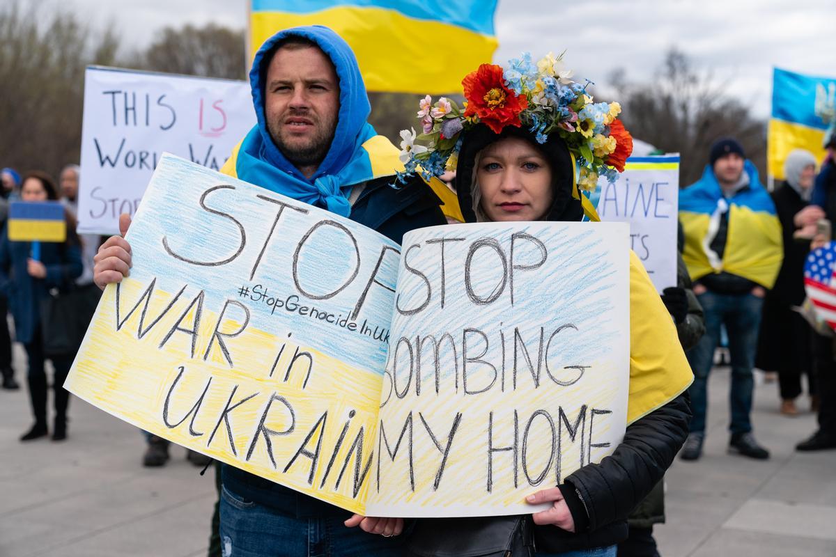 Manifestantes sostienen carteles durante una manifestación contra la invasión rusa de Ucrania en el National Mall en Washington.
