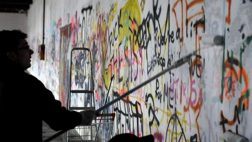 Imagen de archivo de jóvenes locales cubriendo los grafiti que afeaban la estación.