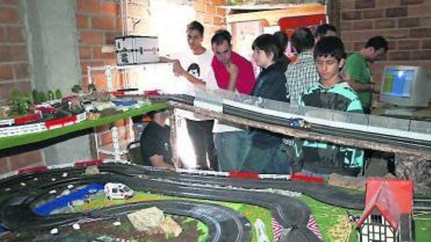 Un grupo de pilotos observa el paso de un coche por un tramo. A la derecha, un piloto, completando su última pasada, ayer, en Lugones.