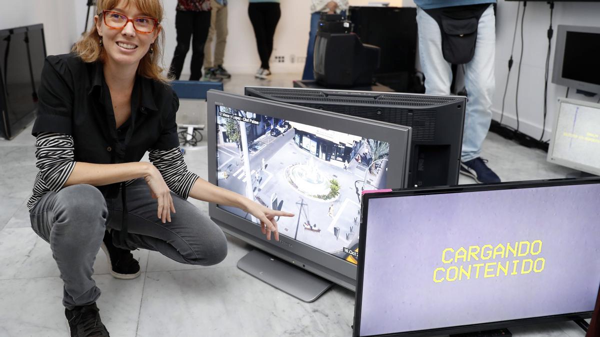 La arquitecta Cristina Maya León junto a algunas televisiones de la instalación ‘Vida pública, donde muestra imágenes de la ciudad, en La Regenta.