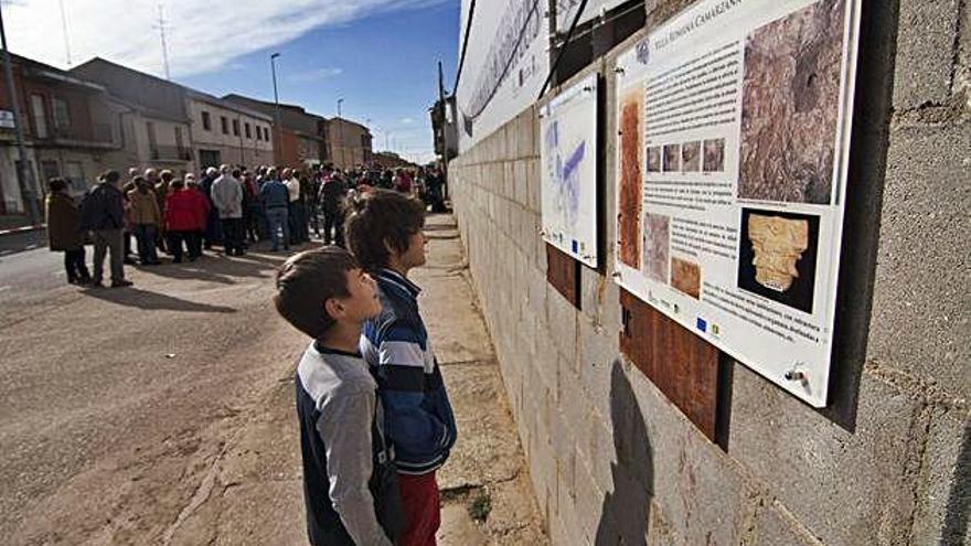 Dos niños leen las explicaciones sobre la villa romana en una concentración ante las instalaciones. A. G.