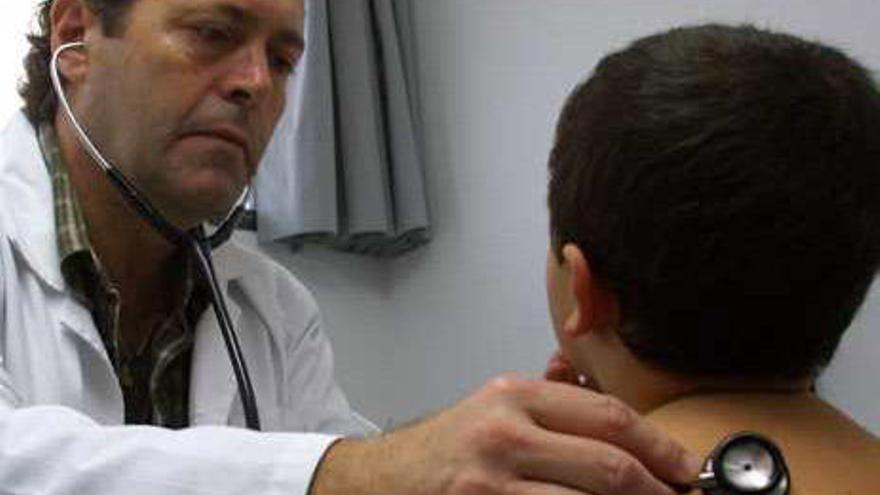 Un pediatra ausculta a un niño en un centro de salud.