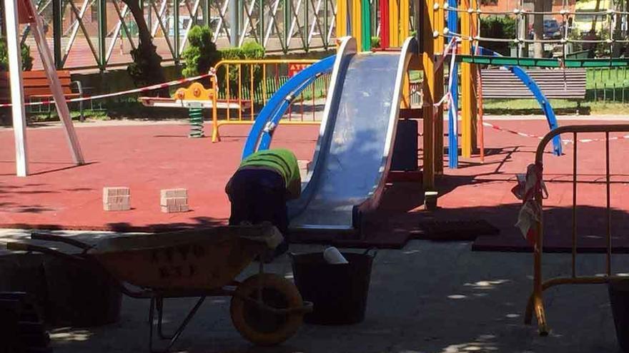 Un operario municipal realizando el cambio del suelo de caucho del parque de Santa Clara.