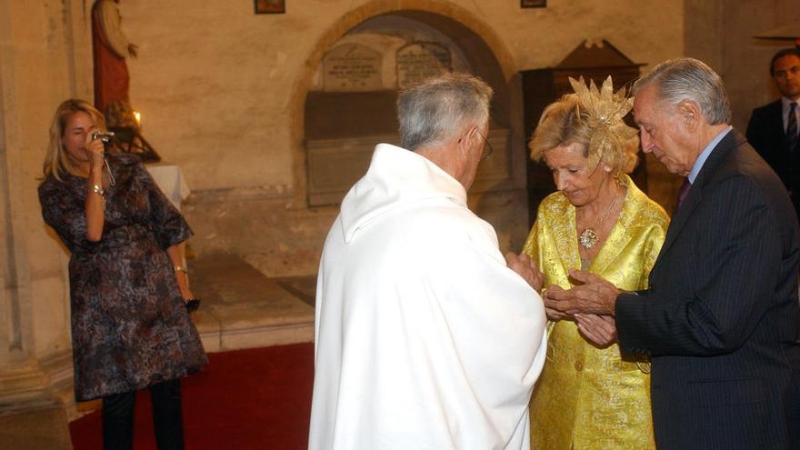 Juan María Urquiola y su esposa se colocan los anillos en la ceremonia de sus bodas de oro, mientras Patricia Urqiola les hace una fotografía.