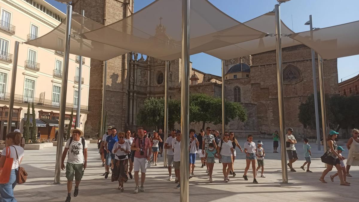 Un grupo de turistas italianos recorre la recién inaugurada plaza de la Reina.