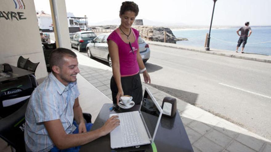 Un cliente en la terraza de un restaurante de El Cotillo próximo a la torre de El Tostón y el puerto pesquero. | gabriel fuselli