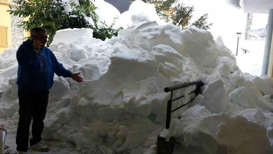 Abajo, a la izquierda, Juan Carlos Susano, con parte de la nieve que se acumula en una de las zonas cercanas a su bar. A la derecha, dos mineros, en la explotación de Cerredo, rodeados de nieve.