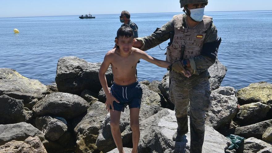 Un militar del ejército español ayuda a un menor migrante procedente de Marruecos a su llegada a Ceuta, a 19 de mayo de 2021, en Ceuta. Antonio Sempere