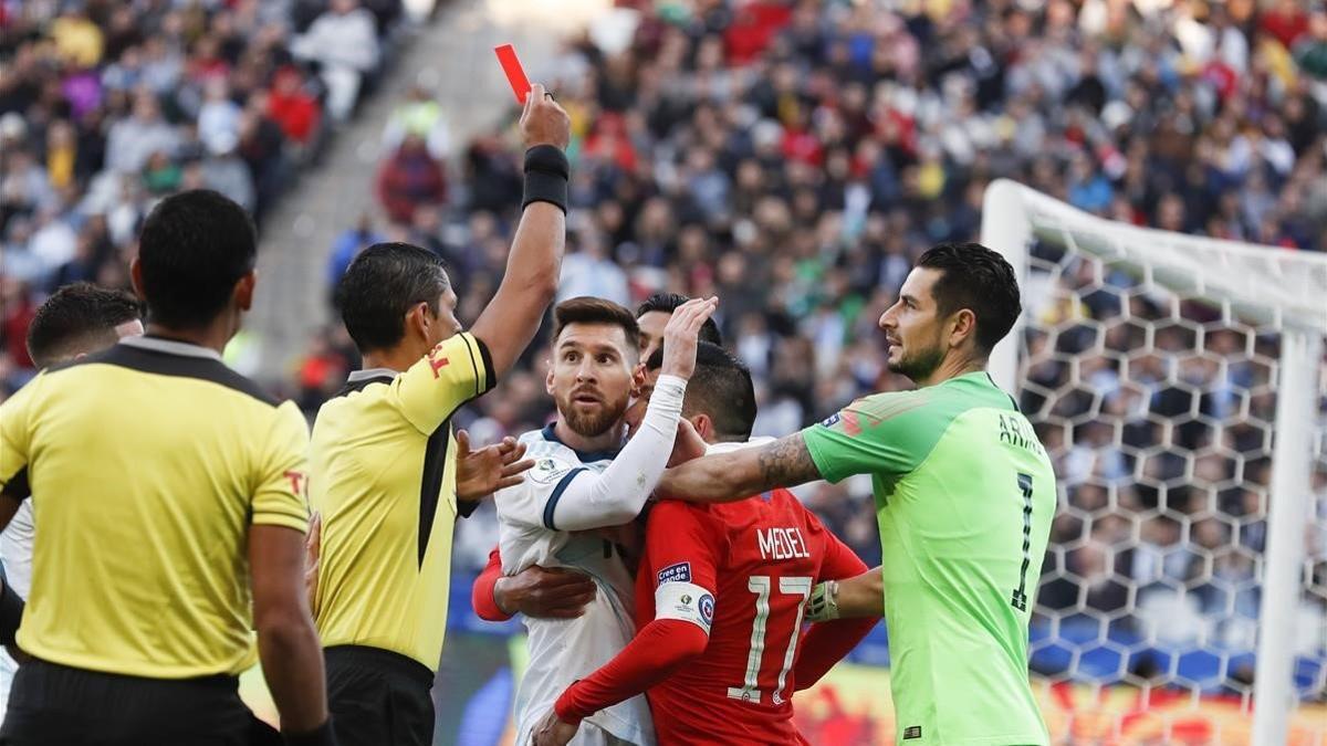 El colegiado muestra la tarjeta roja a Messi y Medel.