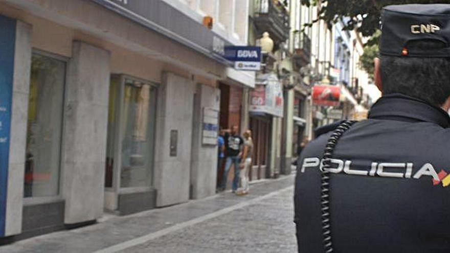 Un agente del Cuerpo Nacional de Policía, de patrulla por una calle comercial.