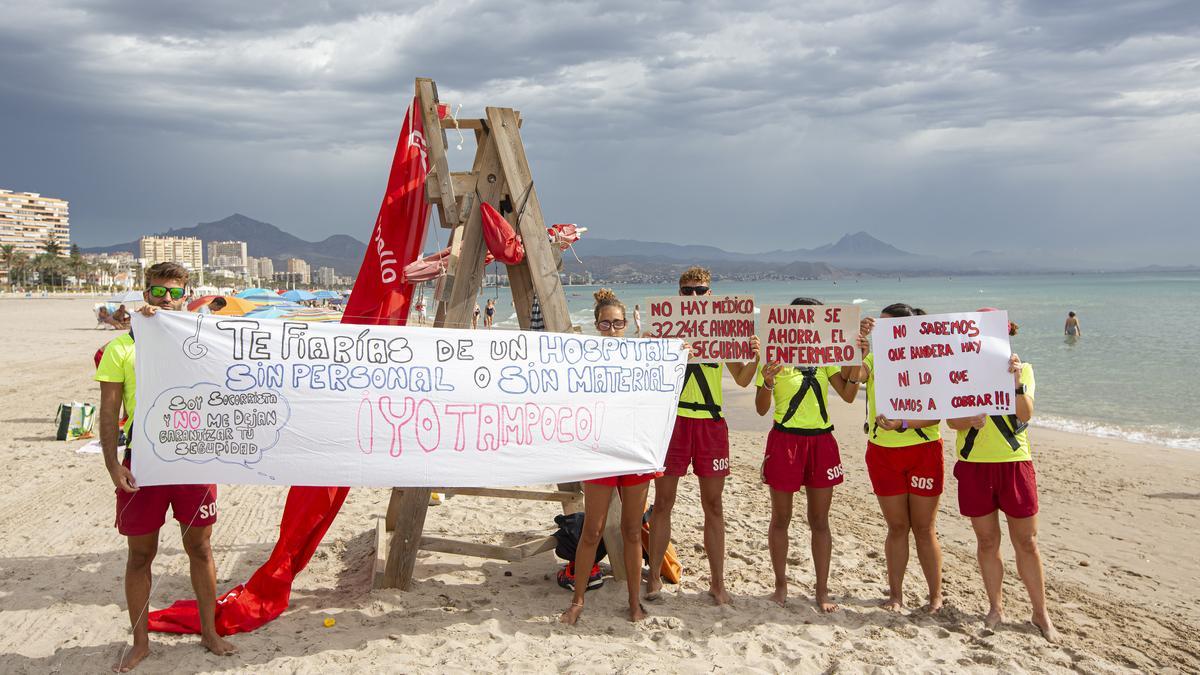 Seis socorristas de El Campello muestran carteles de protesta.