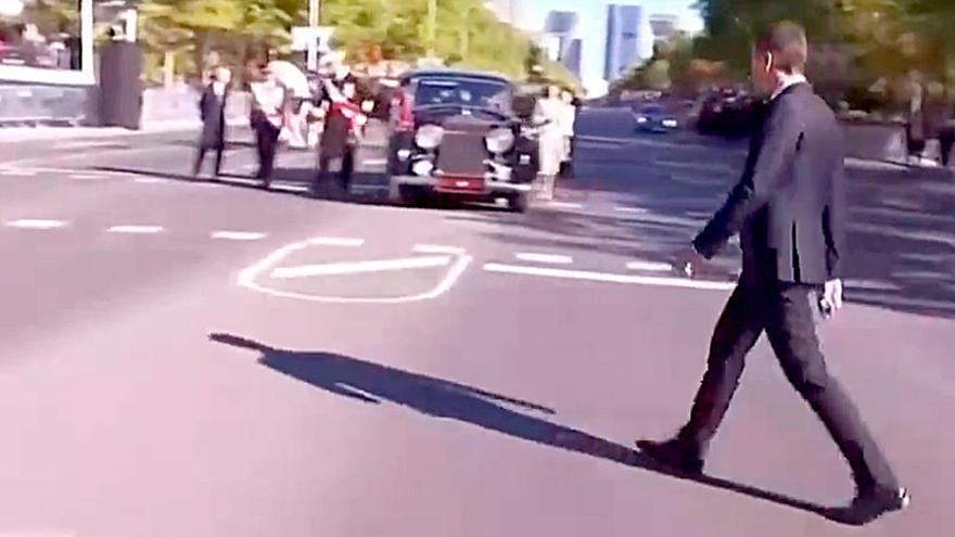 Pedro Sánchez con el coche del Rey al fondo.