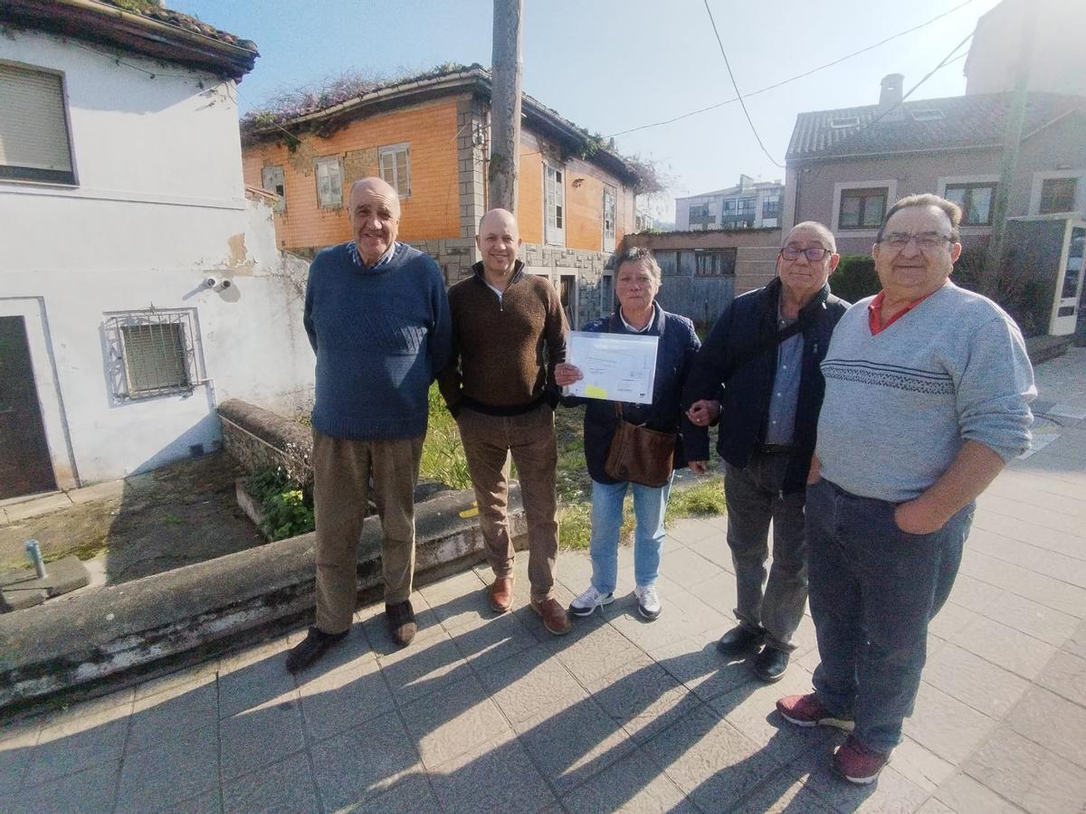 Por la izquierda, Juan Carlos Rodríguez, Juan Carlos González, Lucía Rodríguez, Vidal Alberto Fernández y Lorenzo Campomanes con las dos viviendas en ruina, al fondo, en la parte izquierda.