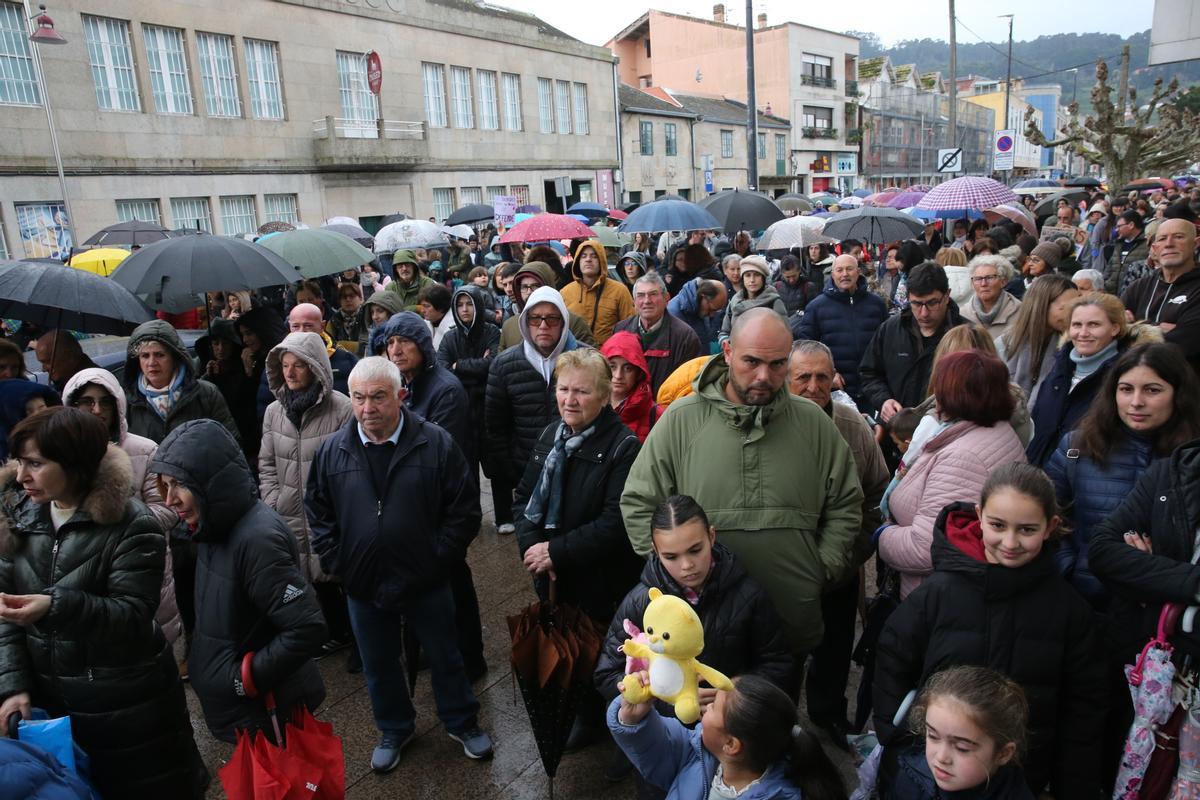 Asistentes a la concentración, con paraguas y capuchas para resguardarse de la lluvia.