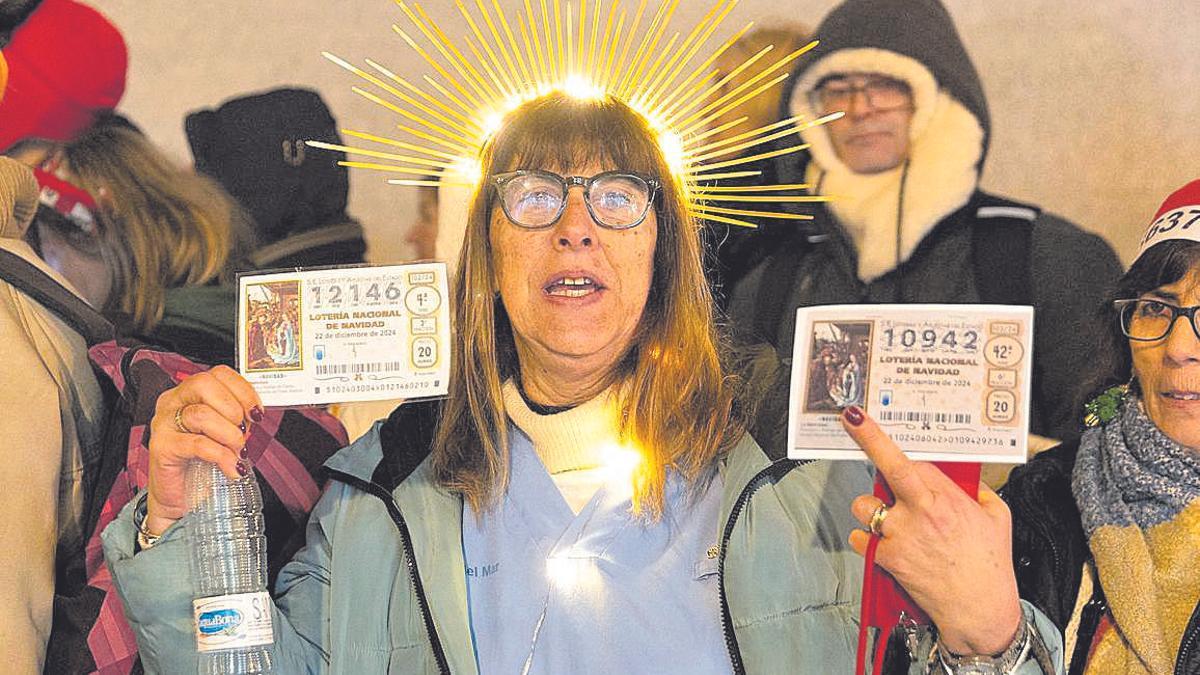 Una mujer, con una corona y con sus décimos de ‘El Obispo de la Lotería’.