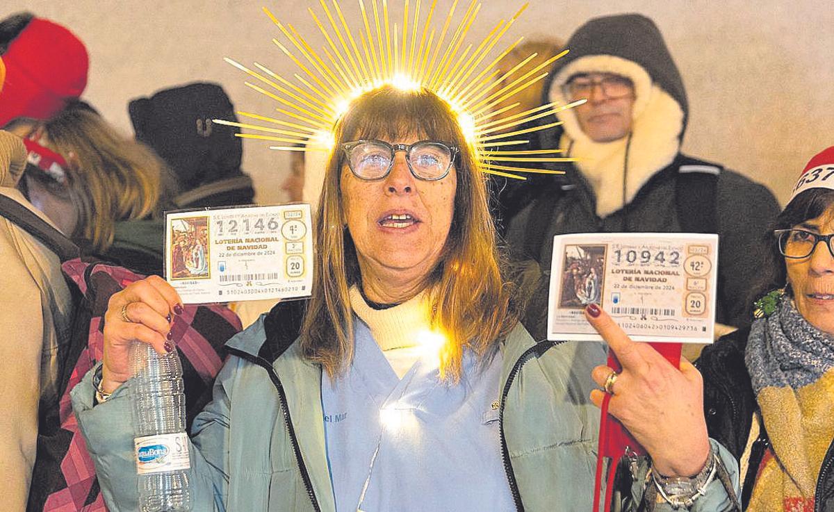 Una mujer, con una corona y con sus décimos de ‘El Obispo de la Lotería’.