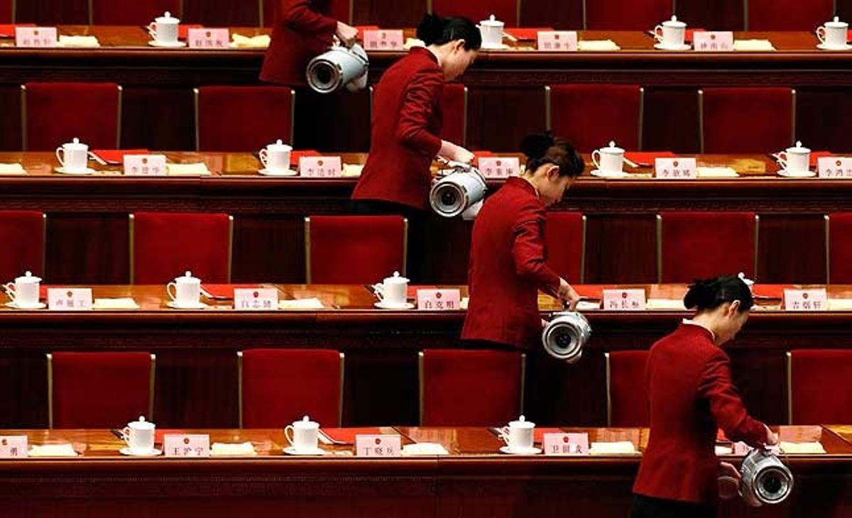 Dones xineses aboquen aigua calenta en unes tasses abans de començar la sessió de clausura del Congrés Nacional de les Persones a Pequín.