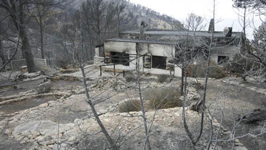 Árboles quemados junto a una casa afectada por el reciente incendio de Sant Joan.