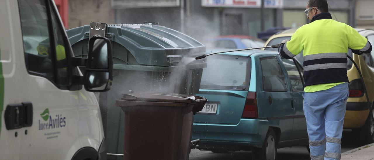 Un empleado de Urbaser desinfecta contenedores en la calle.