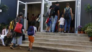 Alumnos y padres en la entrada de la escuela Entença, en Barcelona.