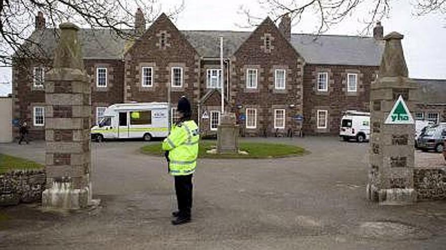 Fotografía de archivo del 27 de febrero de 2008 de un policía haciendo guardia a las afueras del hogar infantil Haut de la Garenne, en Jersey (Reino Unido), donde, fueron hallados los restos de cinco niños, de entre 4 y 11 años, tras una búsqueda de la policía local en este lugar.