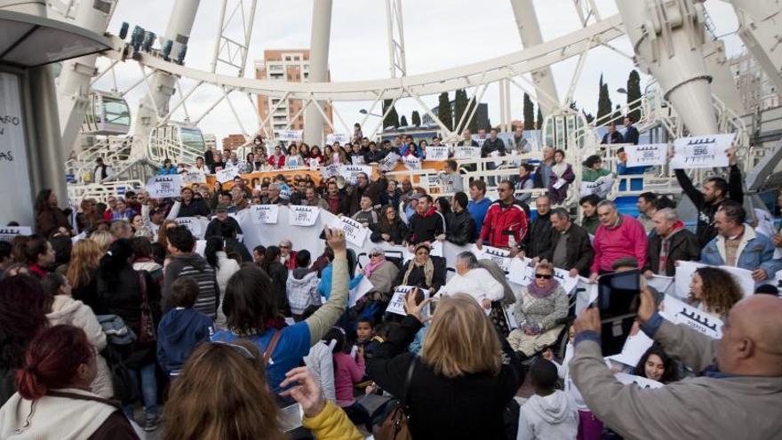 Despliegue de pancartas ante la noria.Un grupo asistente, antes de subir a la atracción.