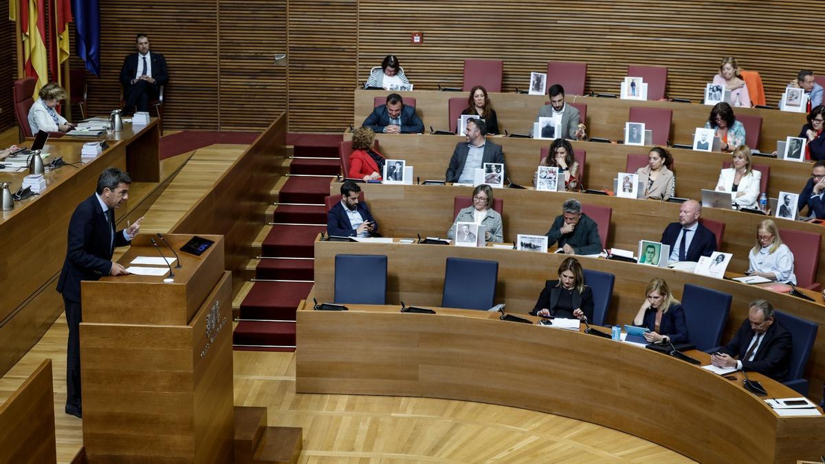 Los diputados del PSPV muestran imágenes de represaliados mientras interviene Mazón.