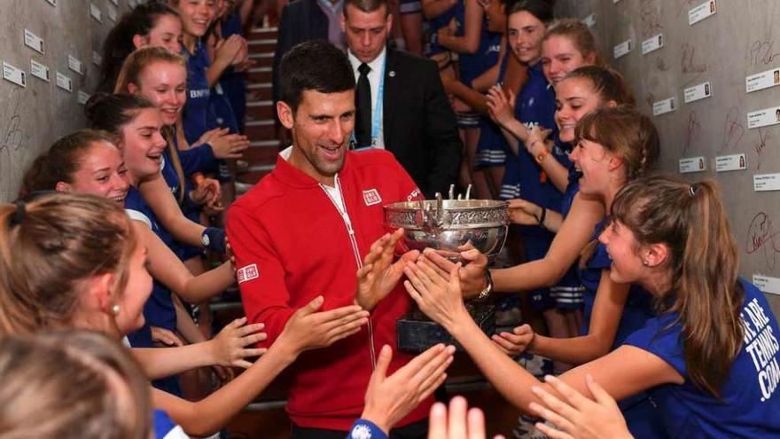 Djokovic celebra su victoria con los recogepelotas. // Pool