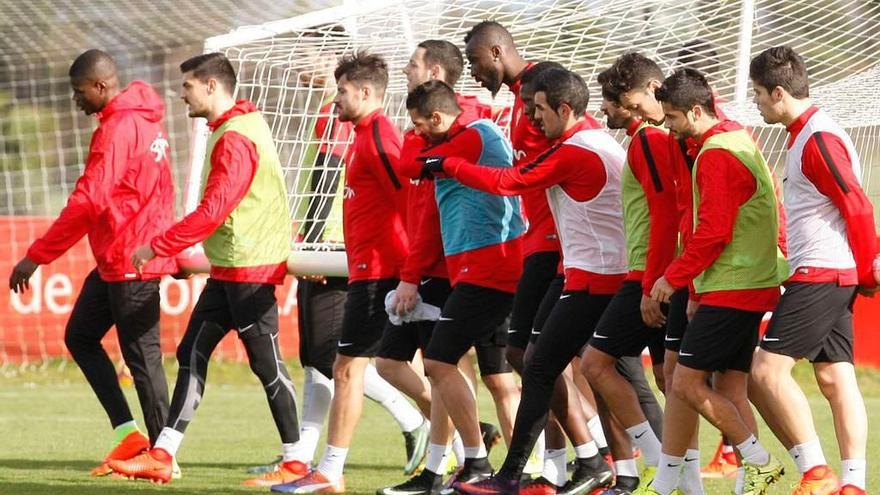 Los jugadores del Sporting, trasladando una de las porterías durante el entrenamiento de ayer.